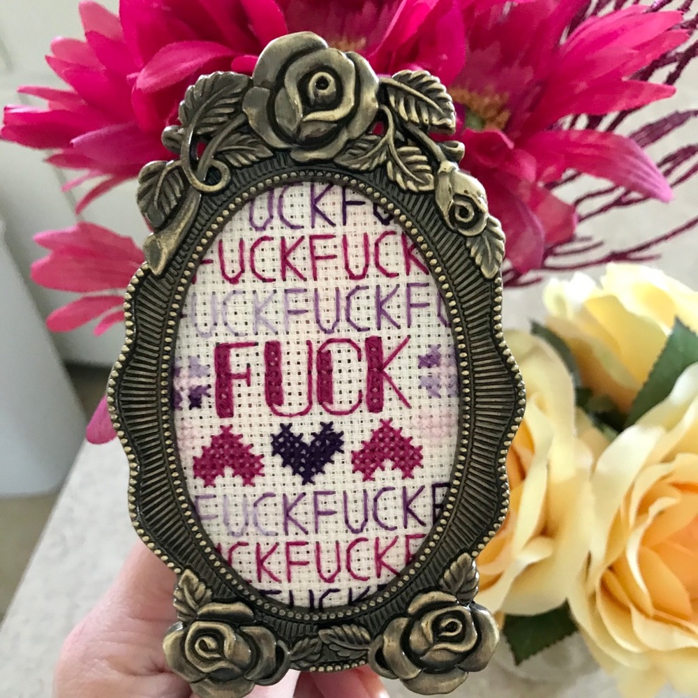 Completed funny cross stitch in floral desk frame